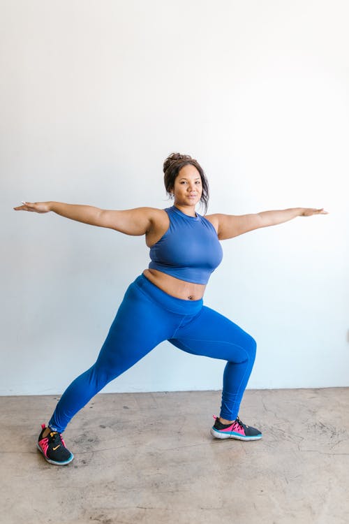 Woman in Blue Activewear Doing Stretching Exercise