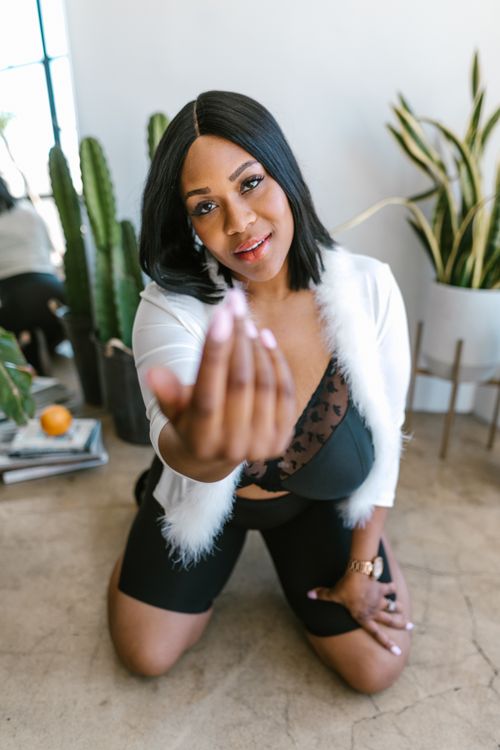 Free Black woman in stylish outfit posing indoors with cactus and houseplants. Stock Photo