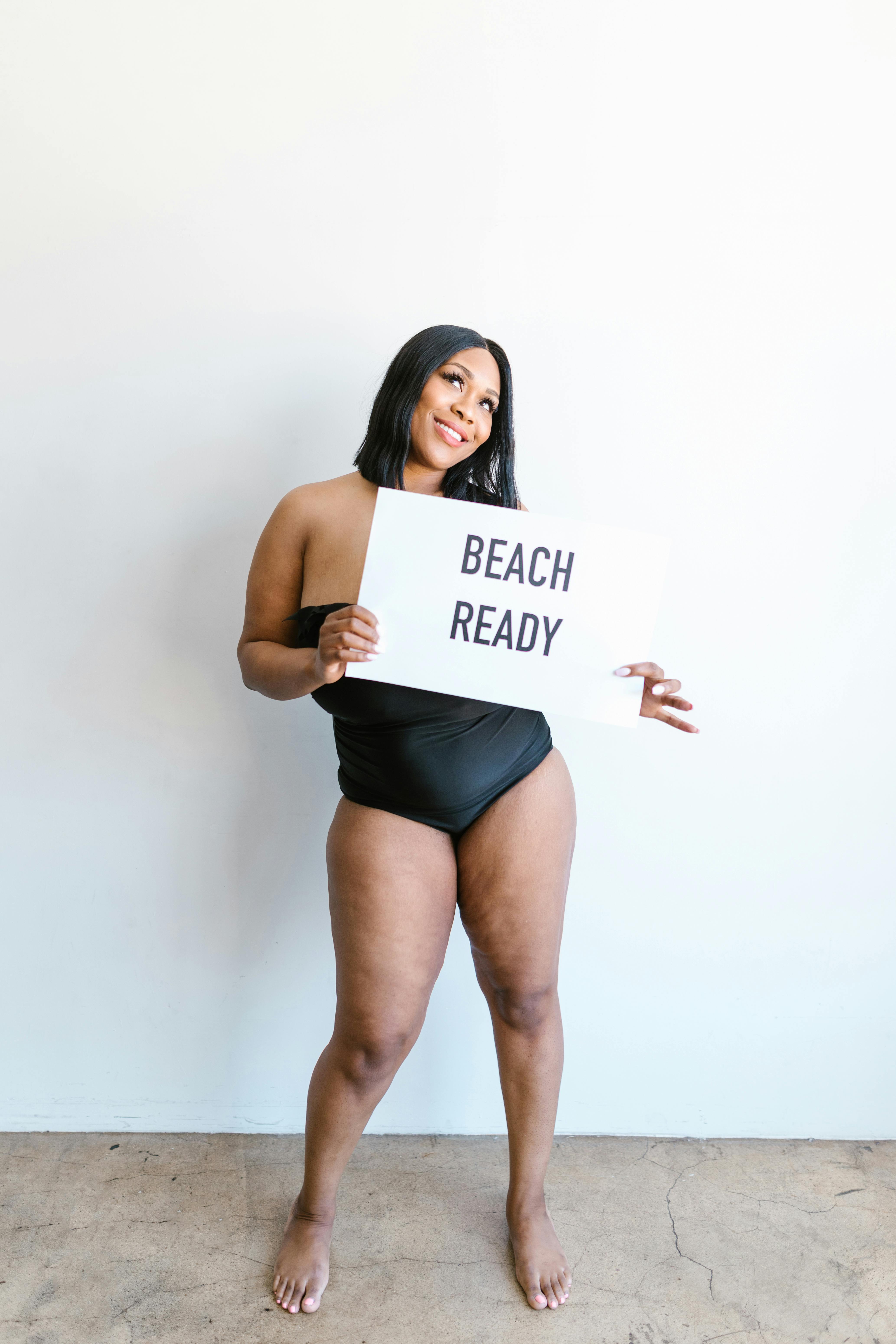 woman in tube swimsuit holding white paper