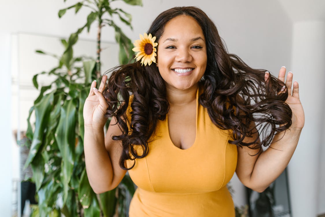 Free Woman in Yellow Tank Top Holding Sunflower Stock Photo