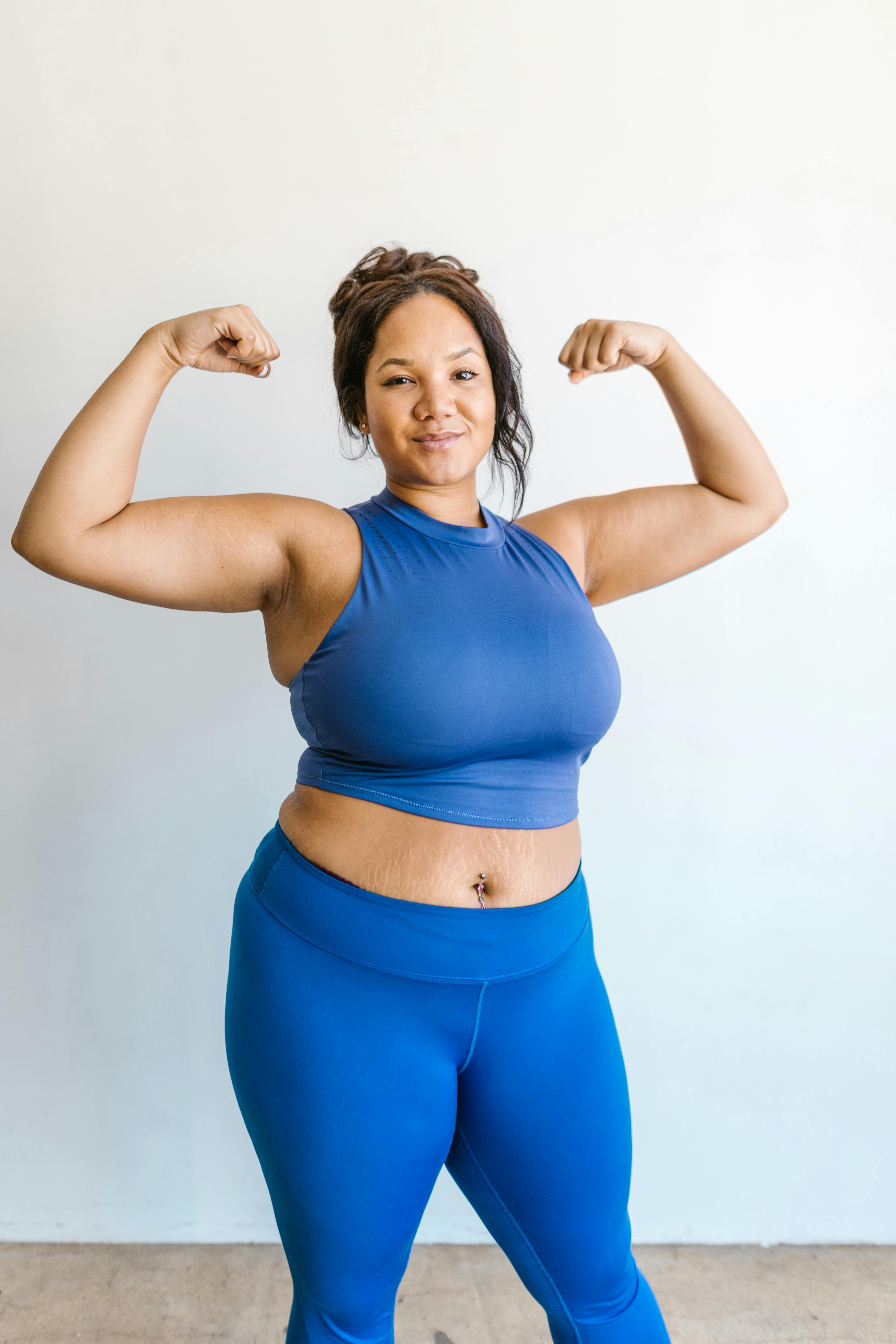 woman in blue activewear posing near white wall