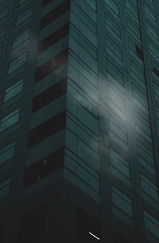 Dark exterior view of a high-rise building facade in Taguig, Philippines, with misty ambiance.