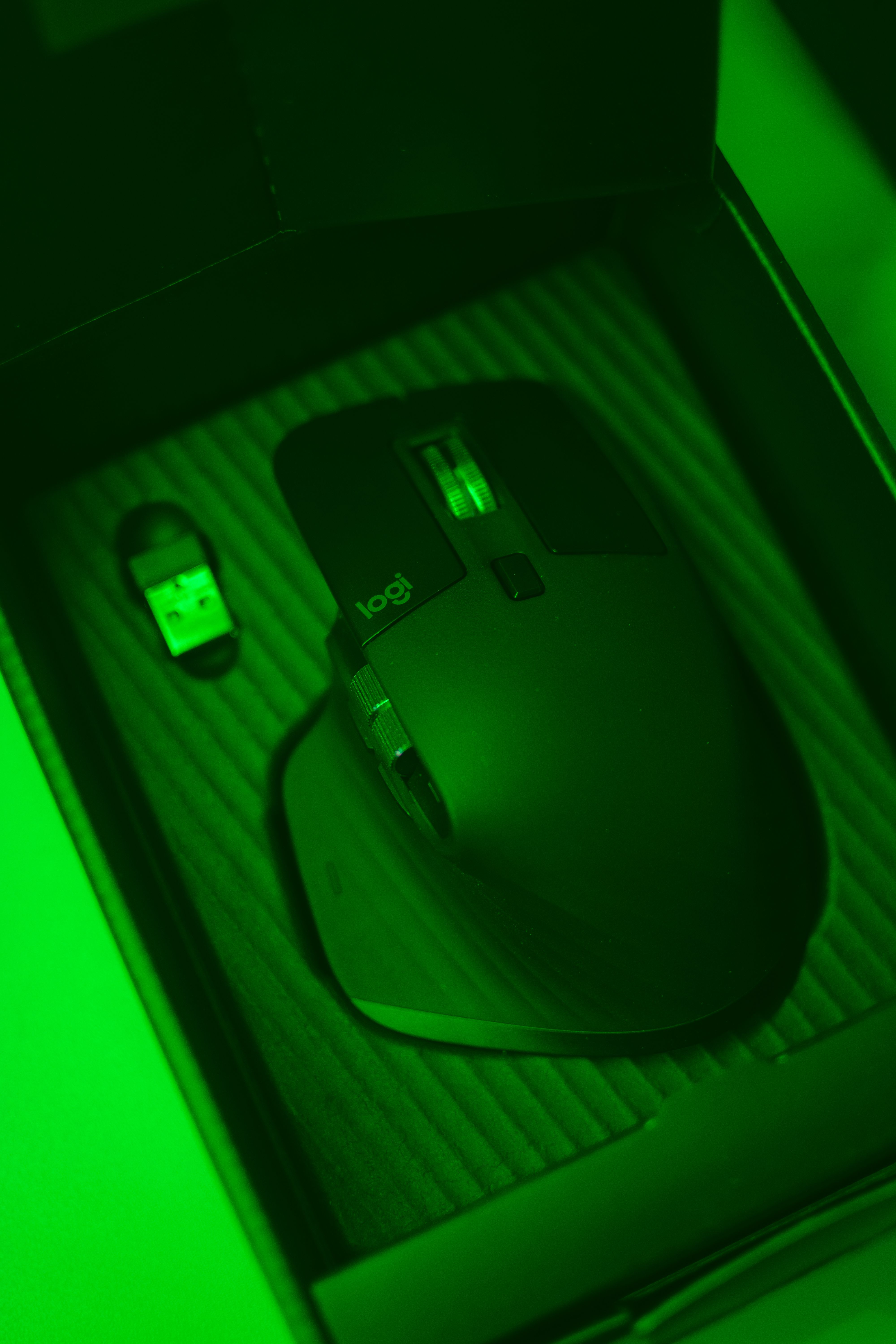 A close-up shot of an illuminated computer mouse in its packaging box, ideal for product photography.