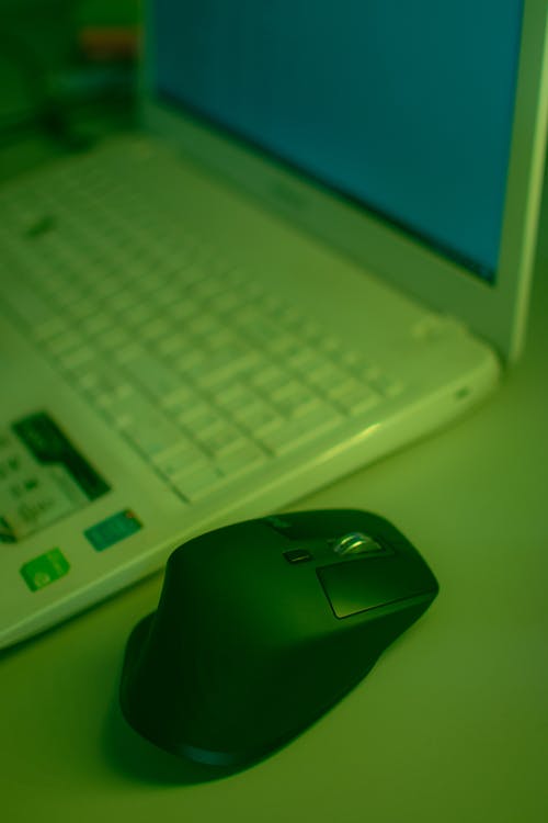 Free Black Hp Cordless Computer Mouse on White Laptop Computer Stock Photo