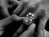 这张黑白特写捕捉了交换结婚戒指的瞬间，凸显出优雅气质