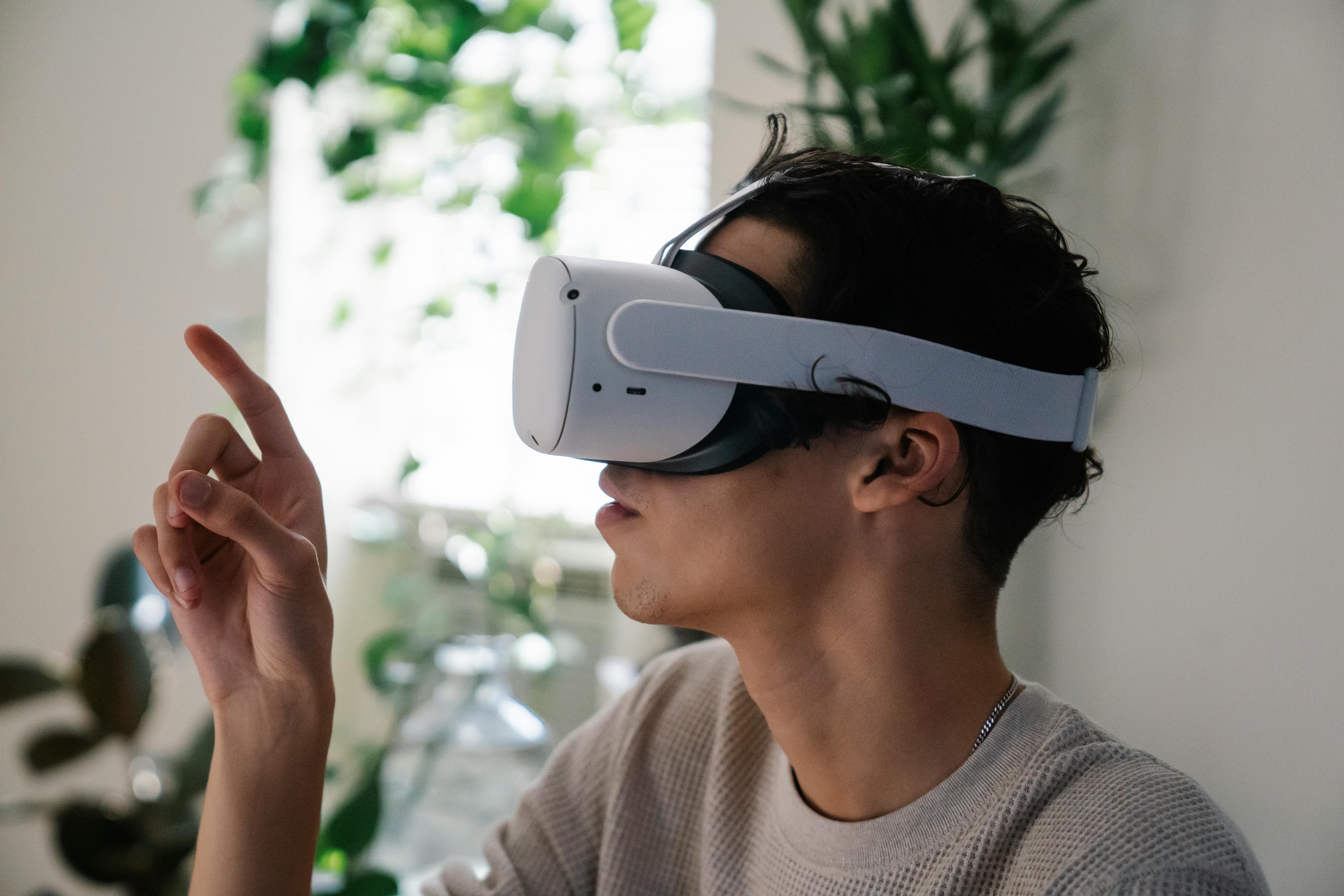 young male millennial in vr goggles looking at finger