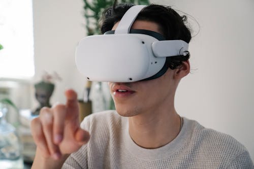 Free Young male interacting with virtual reality headset in apartment Stock Photo