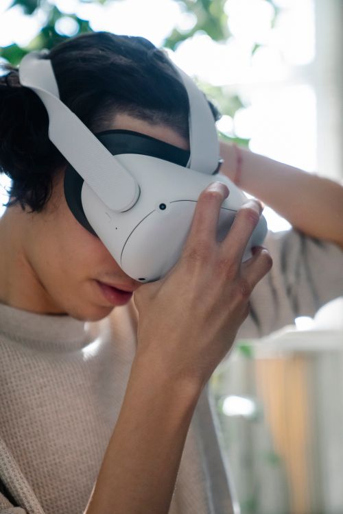 Free A man wearing a VR headset, immersed in a virtual reality experience indoors. Stock Photo