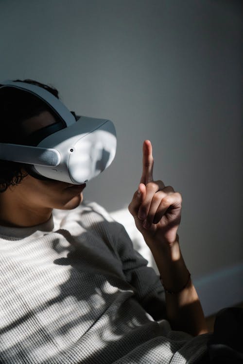 Young guy interacting with VR goggles at home