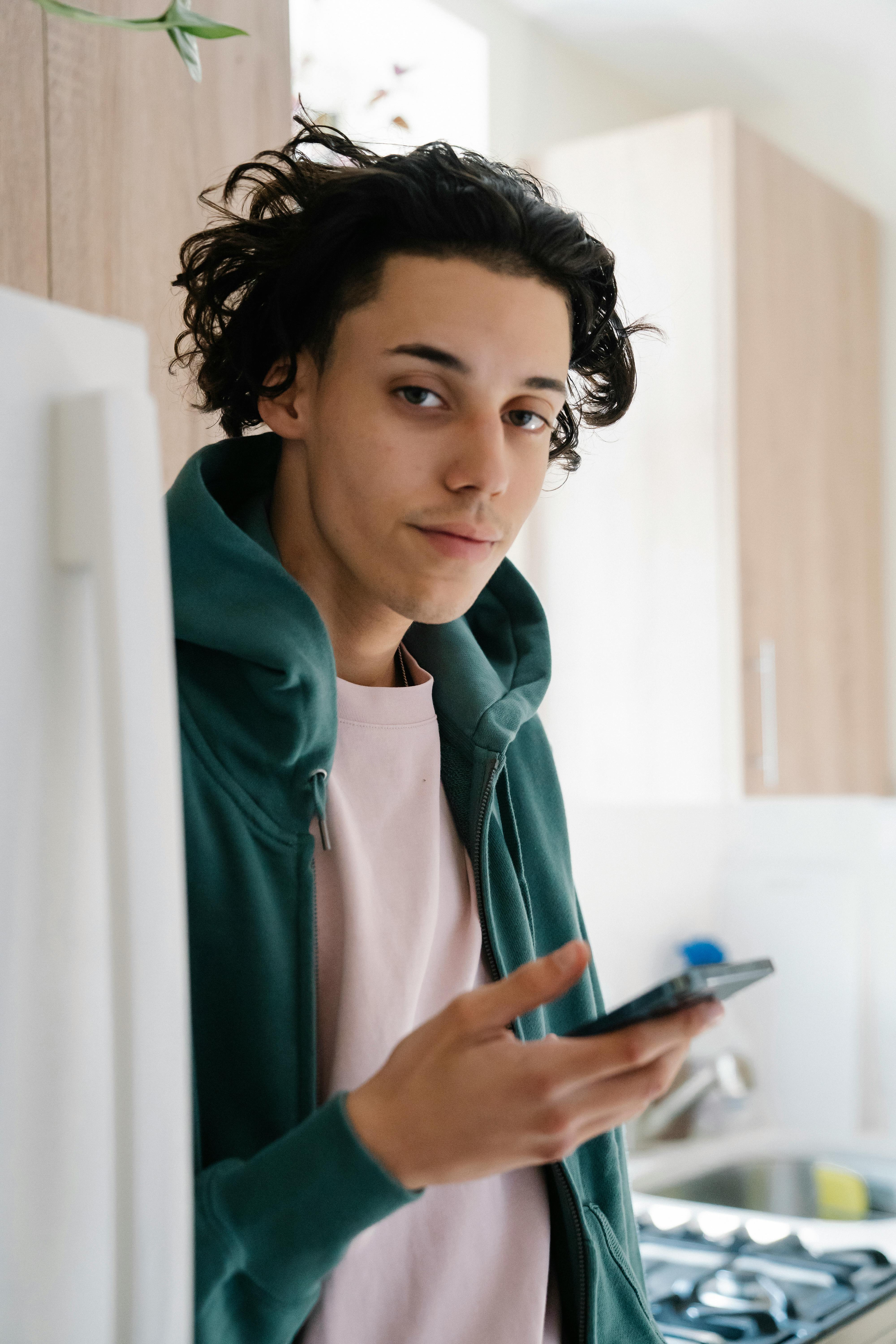 young man using smartphone in kitchen