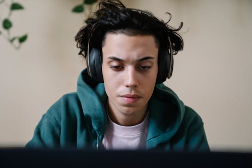 Serious man in headphones working on laptop