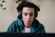 Serious man in headphones working on laptop