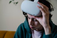 Man taking off VR headset while sitting on sofa