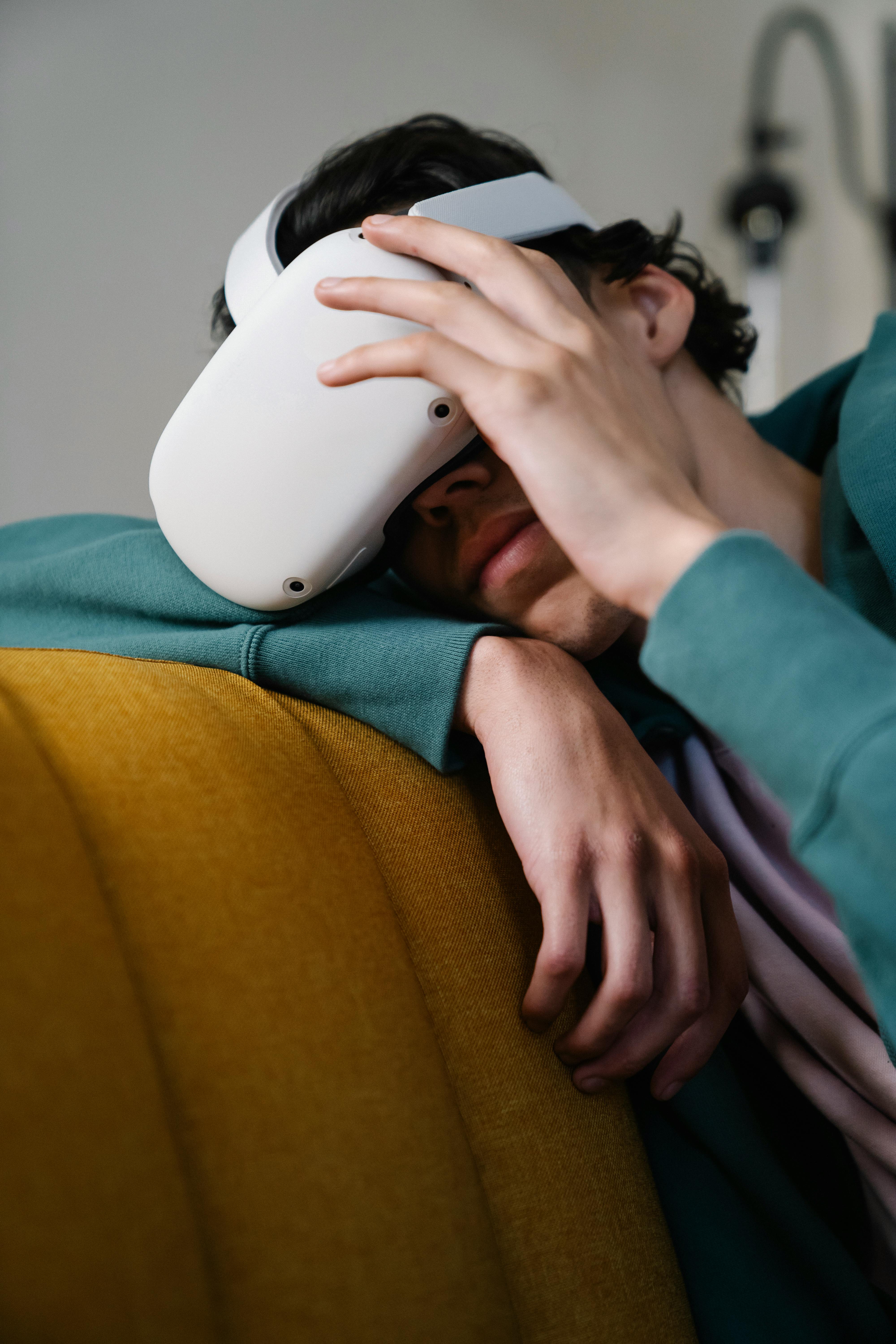 man in headset experiencing virtual reality on couch