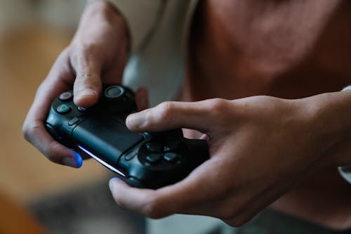 Free Crop gamer with joystick playing video game at home Stock Photo