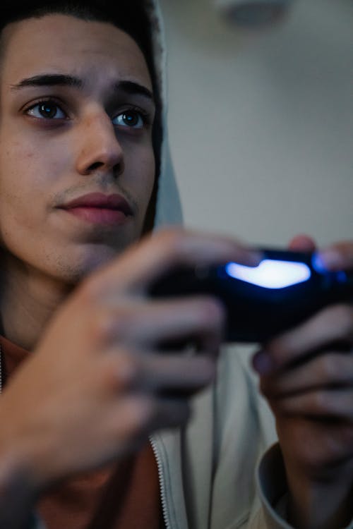 Crop ethnic man with joystick playing video game at home