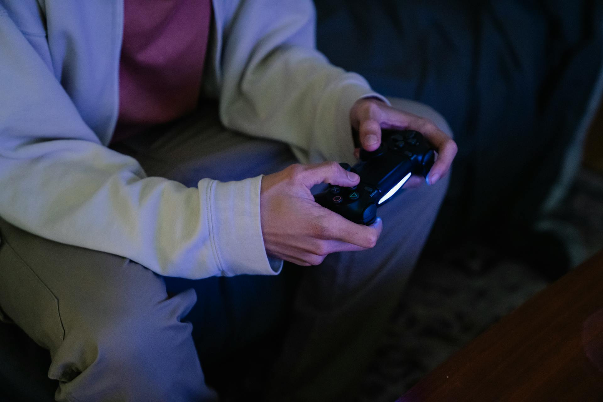 A faceless man playing video games indoors, emphasizing relaxation and entertainment.