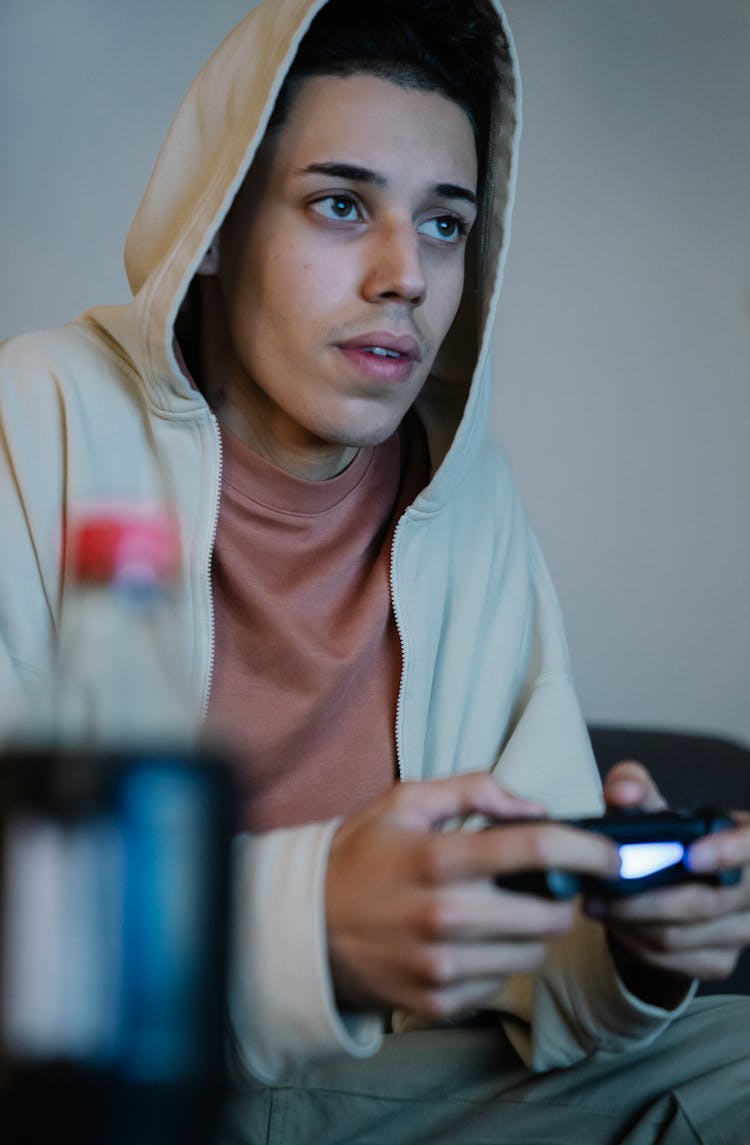 Ethnic Man With Console Controller Playing Video Game In House