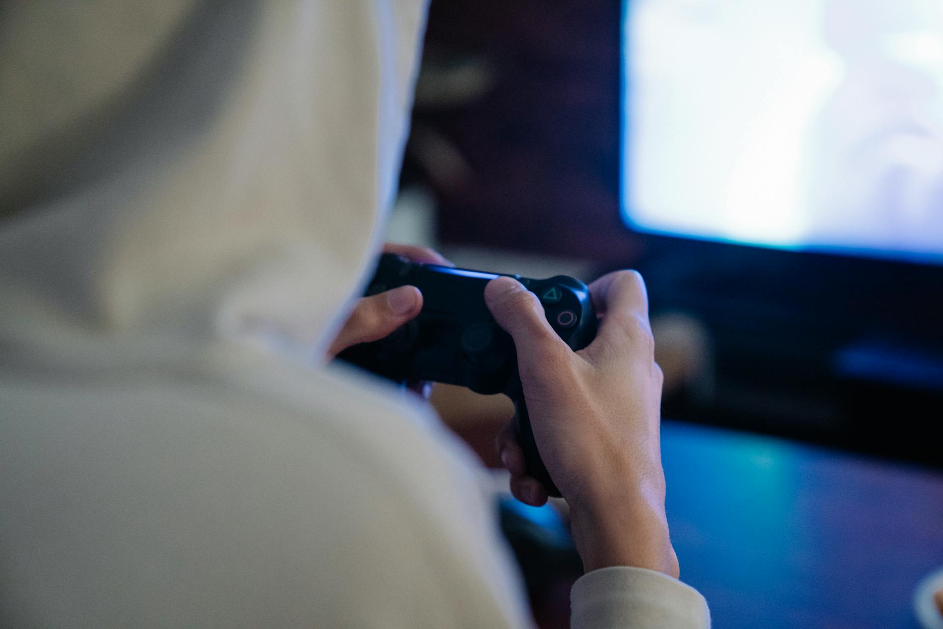 Close-up of a person intensely playing video games indoors with a console controller.