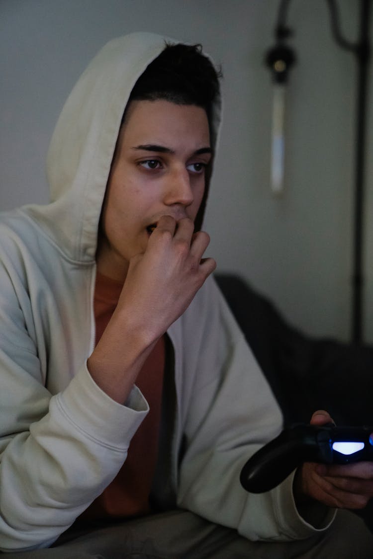 Ethnic Man With Gamepad Playing Video Game At Home