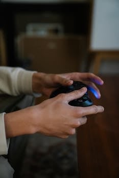 Close-up of hands gripping a game controller indoors, perfect for gaming and entertainment themes.