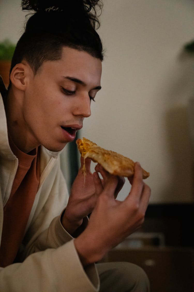 Ethnic Man Eating Tasty Pie Slice At Home