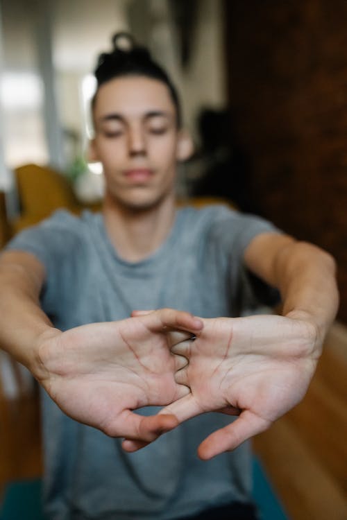 Male teenager stretching arms while cracking knuckles
