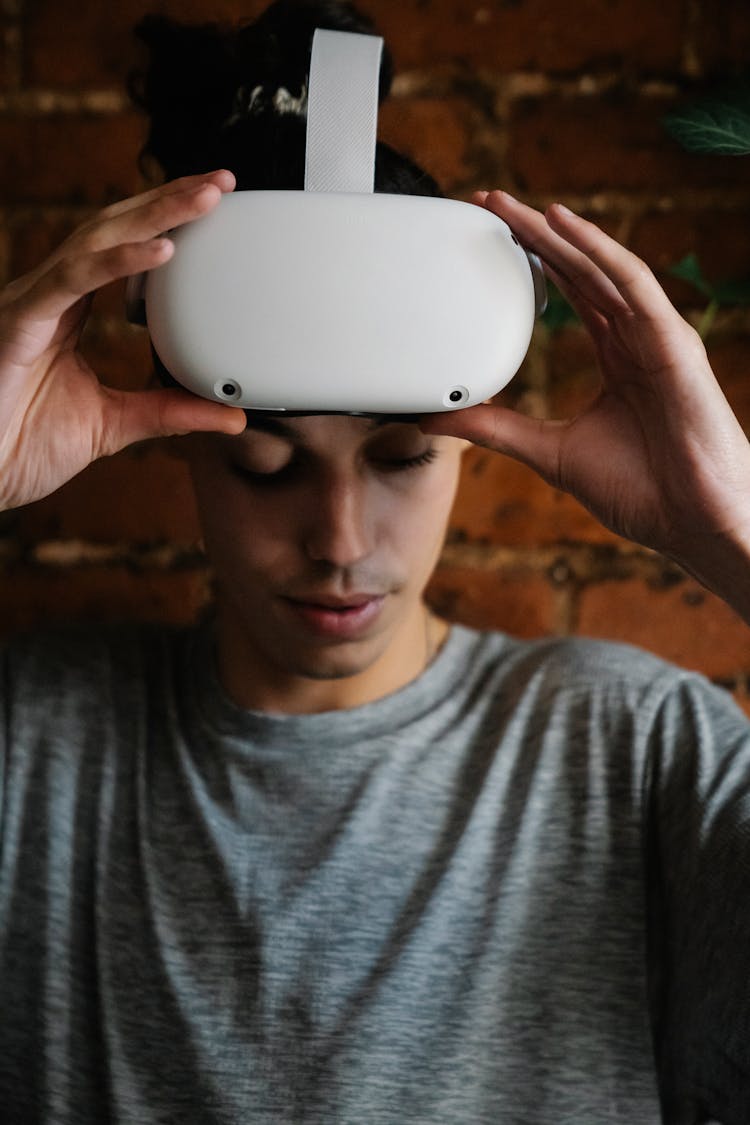 Young Man Putting On Goggles Of Virtual Reality