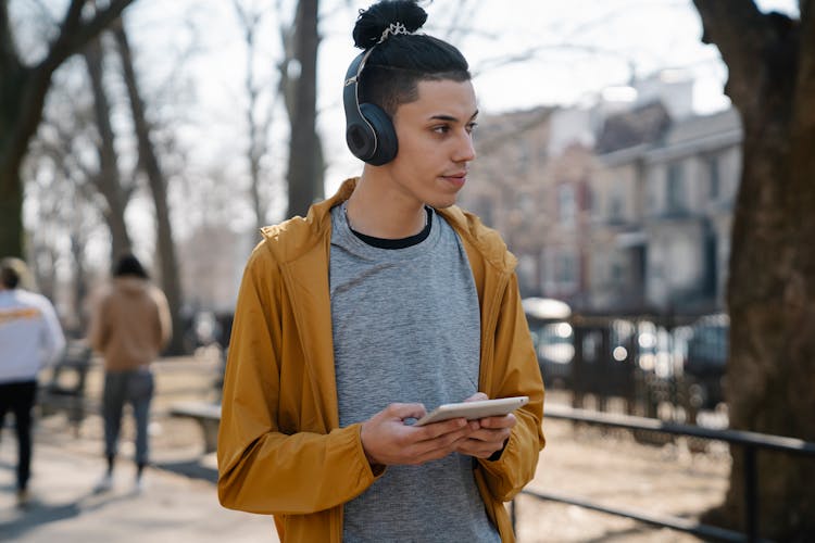 Teen Listening To Music While Walking In Park