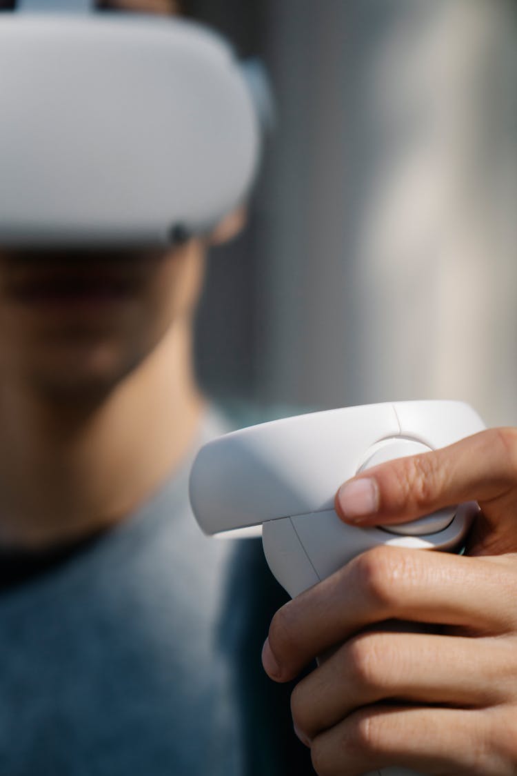 Crop Man Holding Controller Of VR Goggles