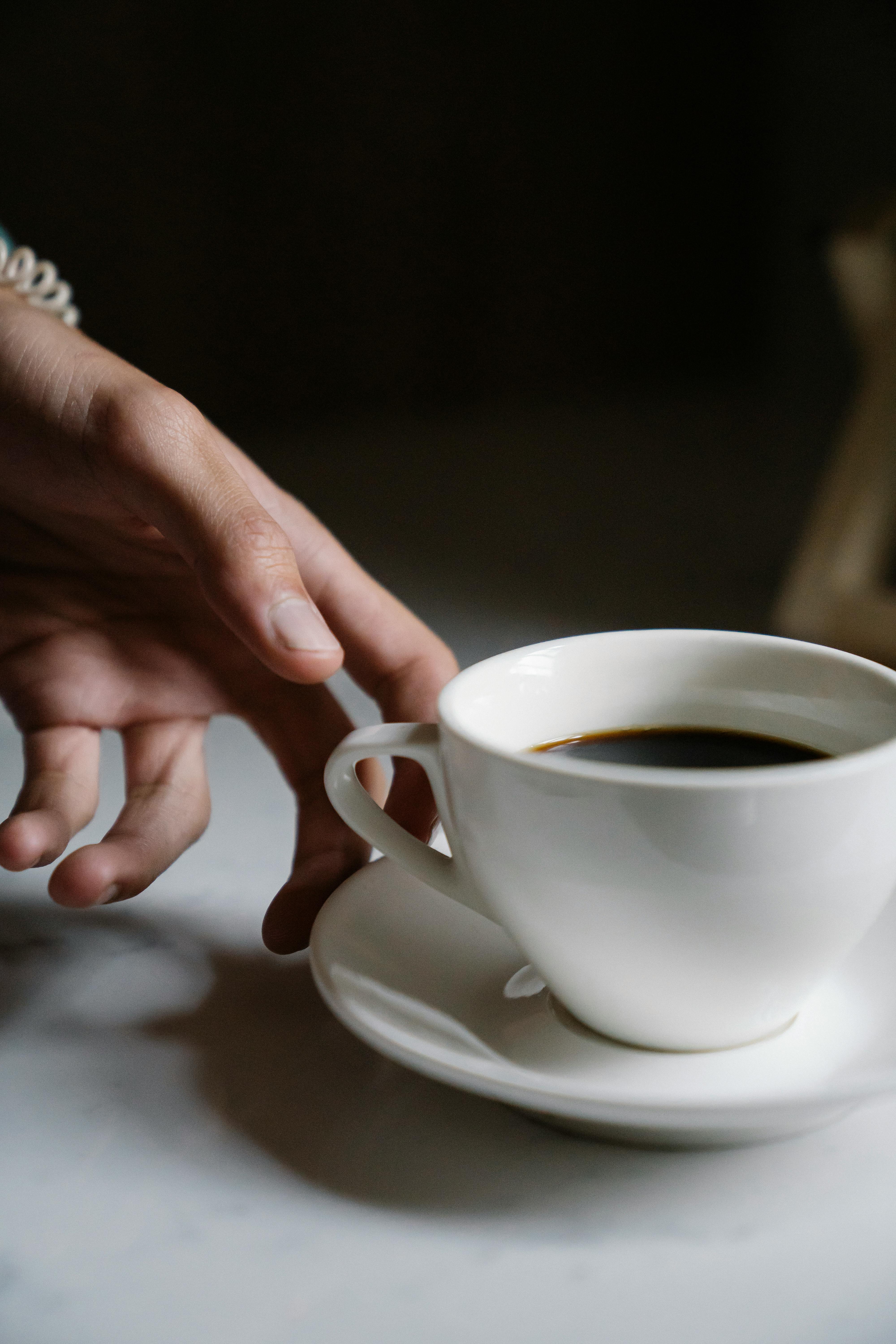 crop person with cup of coffee in cafe