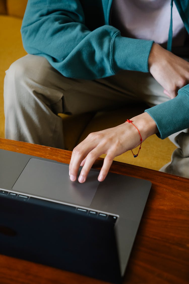 Crop Freelancer Working On Laptop On Sofa At Home