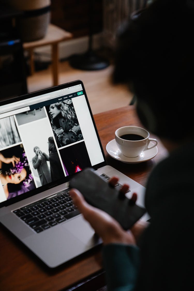 Crop Person With Smartphone Against Photos On Laptop Screen