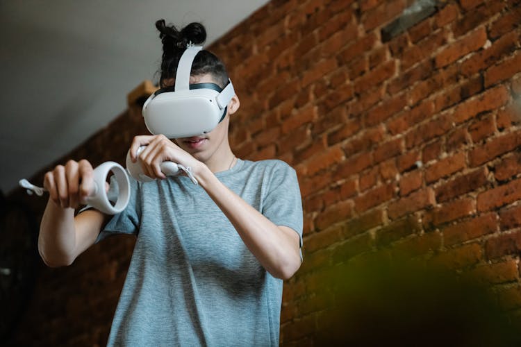 Gamer In VR Goggles Playing Video Game In Loft House