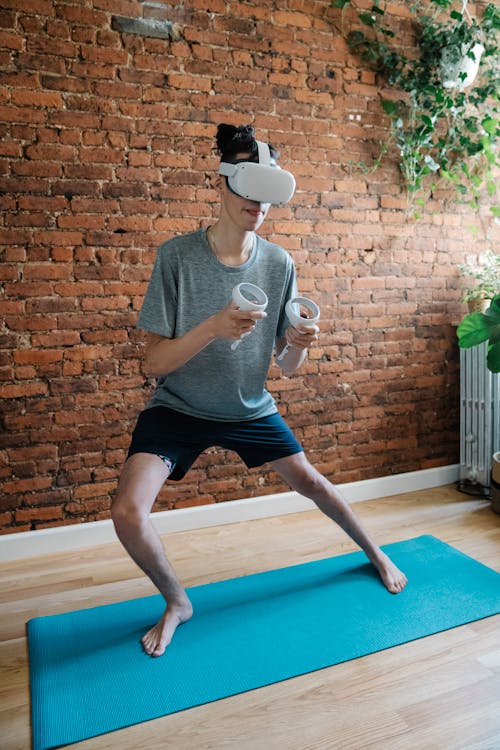 Gamer in VR goggles practicing yoga on mat at home