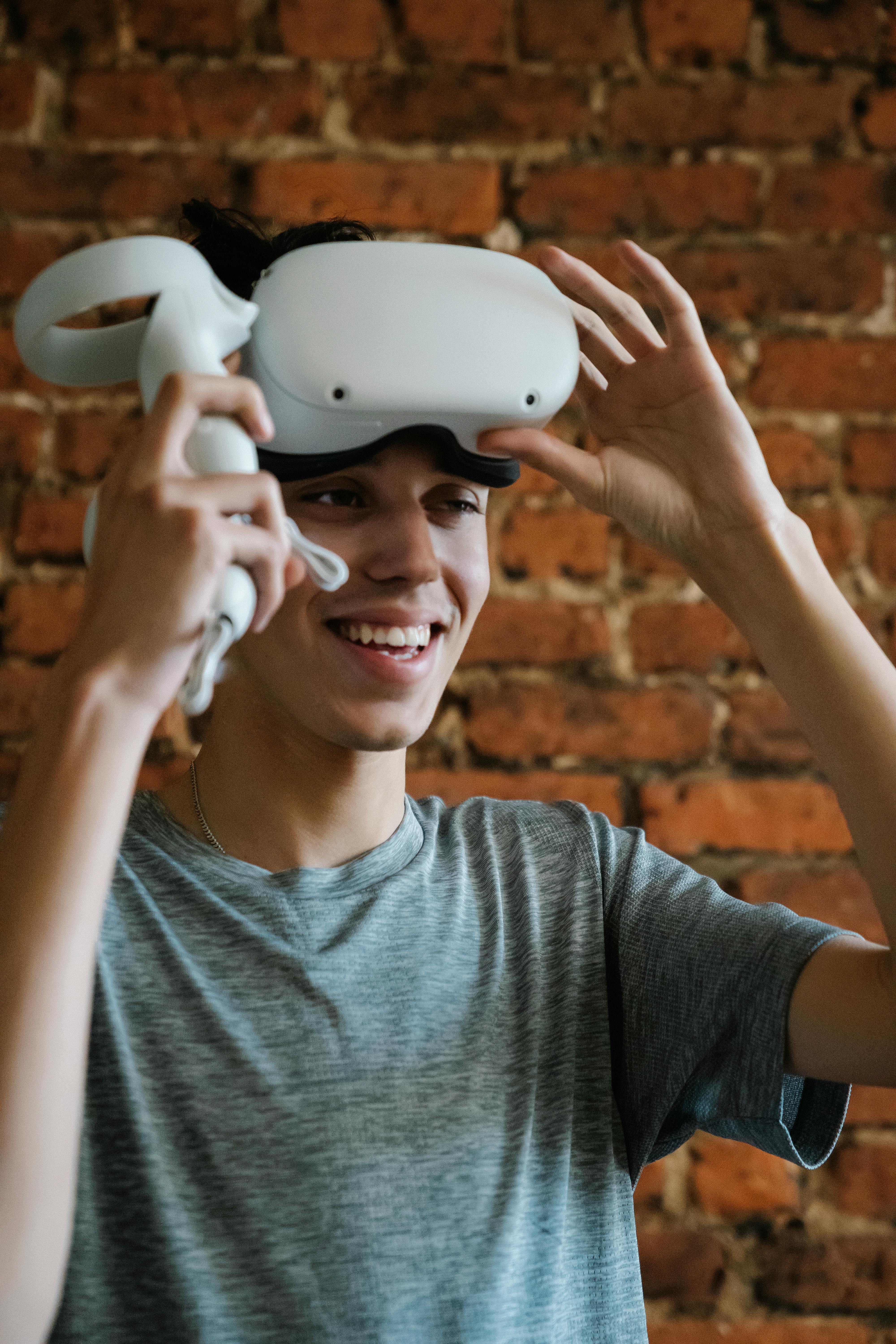 smiling ethnic man in vr headset against brick wall