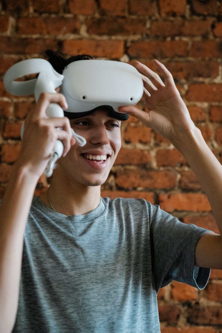 Smiling Ethnic Man In VR Headset Against Brick Wall