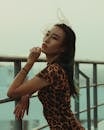 A Woman in Leopard print Dress Standing Near the Metal Railings