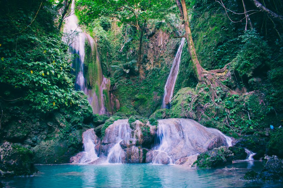 People rappelling down a waterfall during canyoneering at Kawasan Falls, Cebu, Philippines