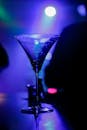 在夜总会充满活力的灯光下，水晶马提尼杯闪闪发光