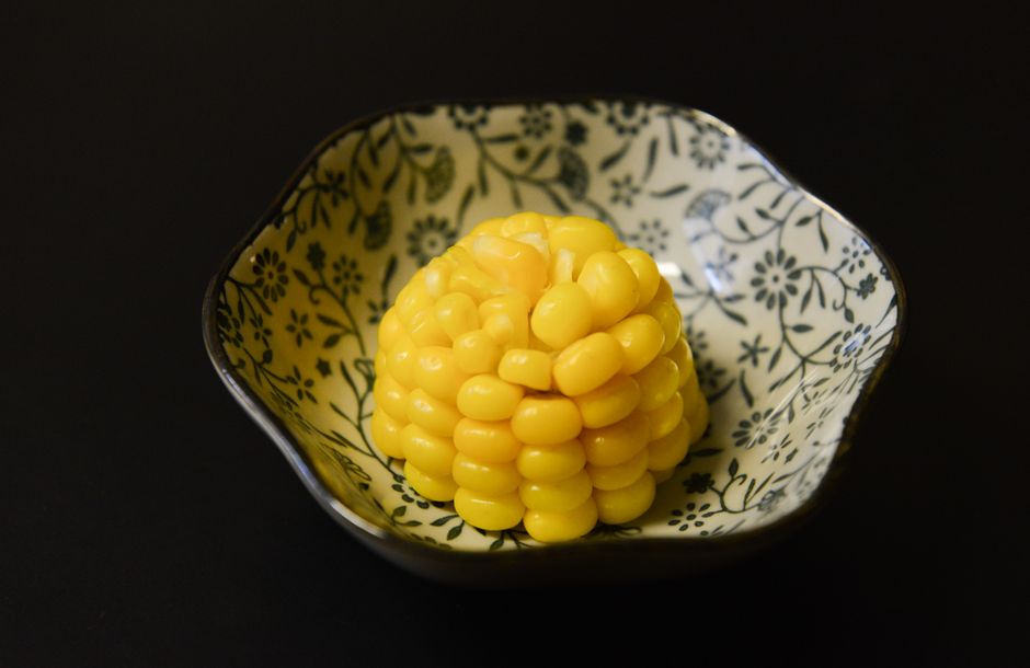 A decorative bowl with a portion of sweet yellow corn, ideal for healthy eating visuals.