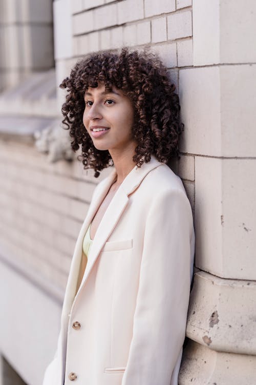 A Woman Wearing a Blazer Leaning on a Wall