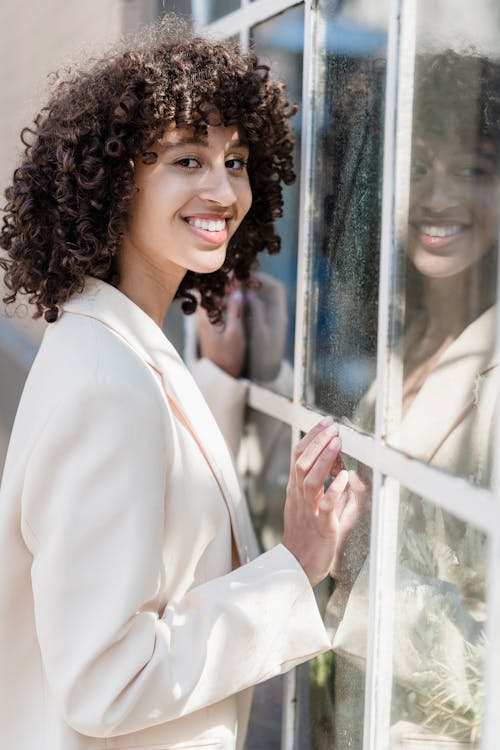 Delighted ethnic woman near window on street