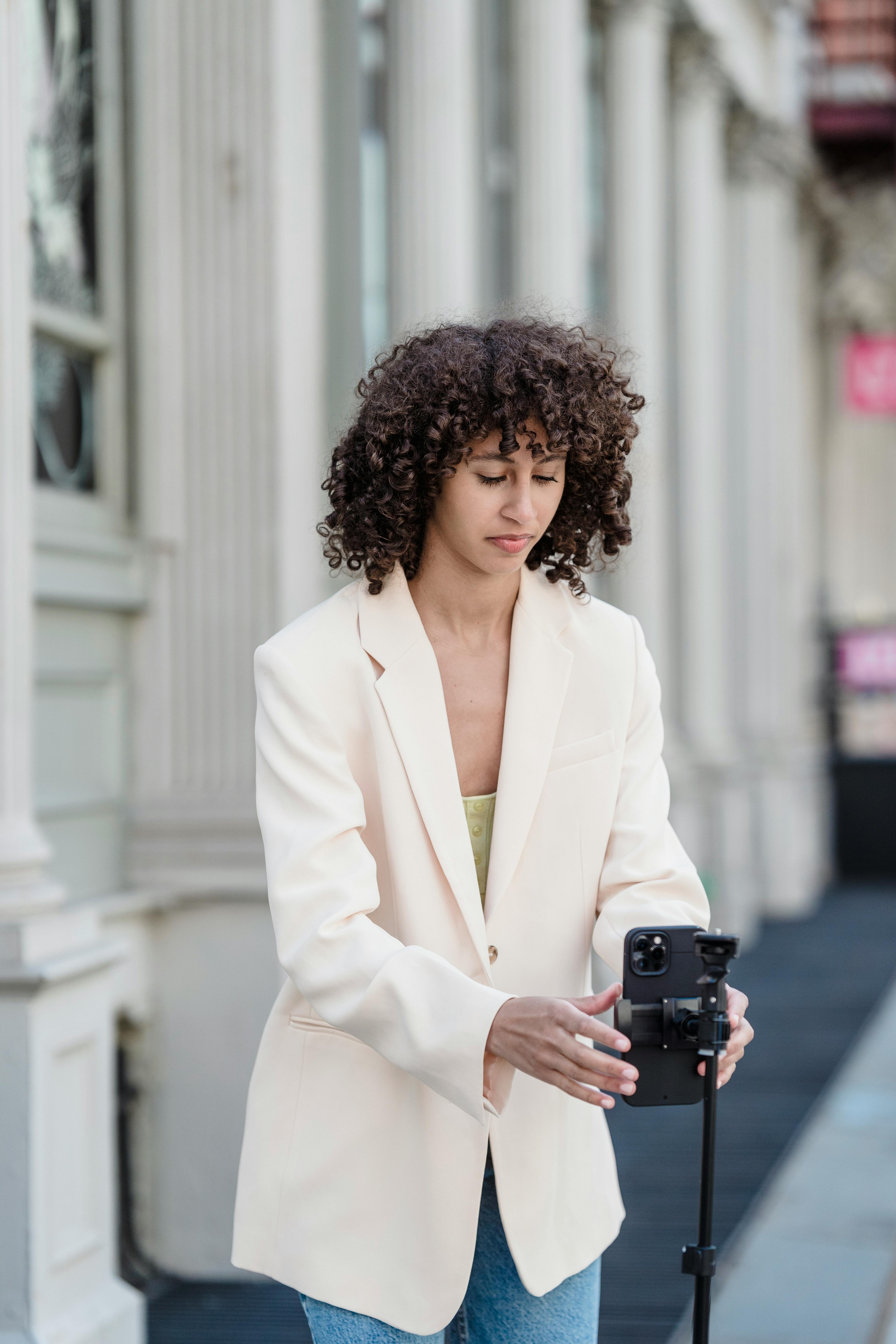 ethnic blogger with smartphone on city street