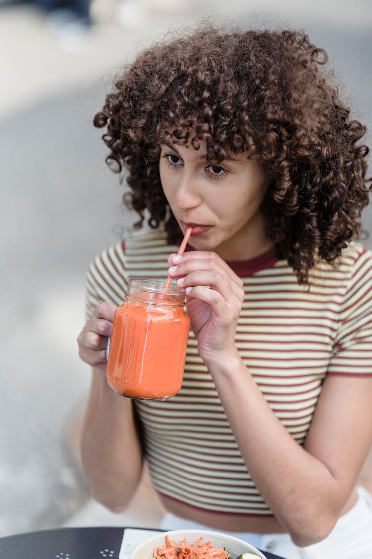 Ethnic Woman Drinking Delicious Smoothie In Street Cafe