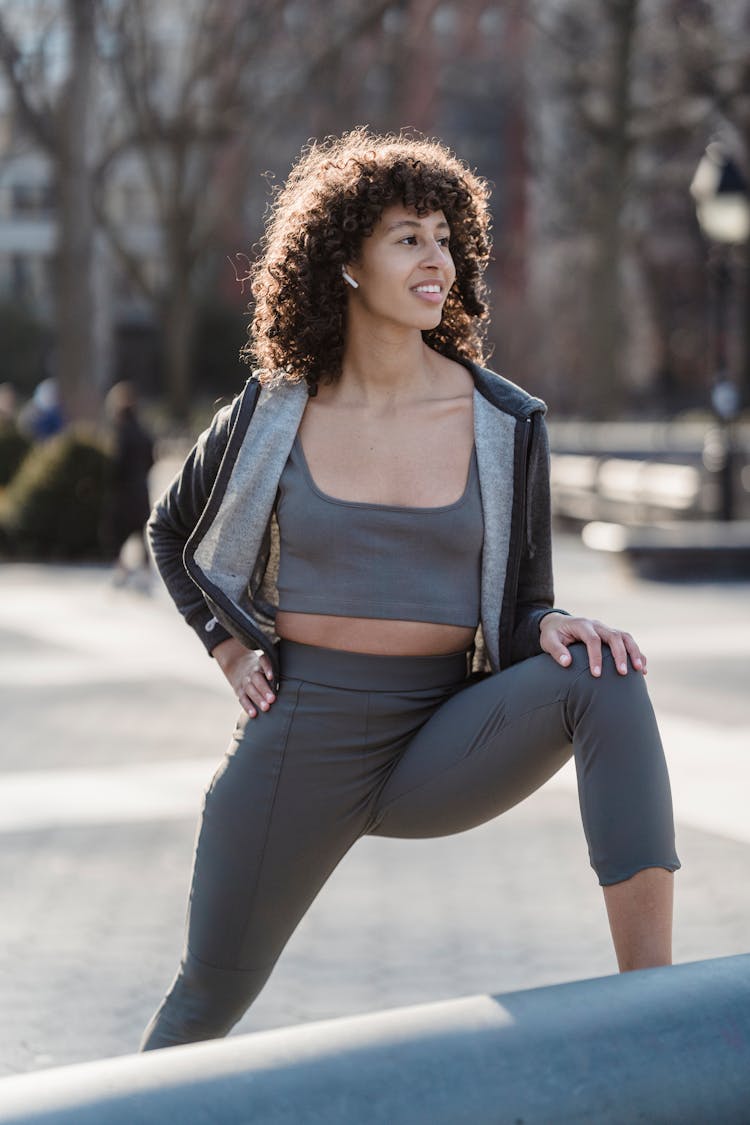 Ethnic Sportswoman In Earbud Working Out On Street