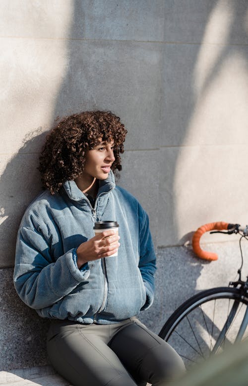 Free Positive ethnic woman with cup of takeaway coffee Stock Photo