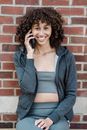 Smiling ethnic woman speaking on smartphone