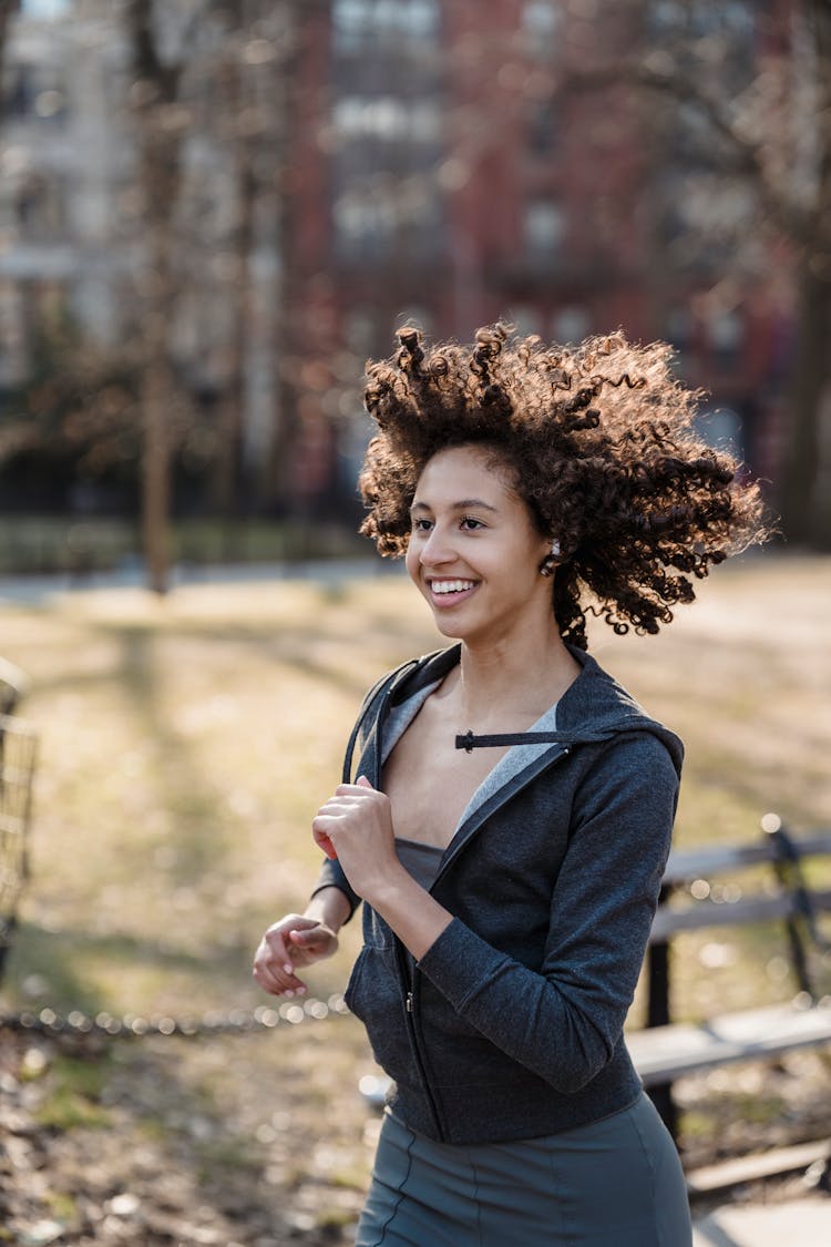 Smiling Ethnic Woman Listening To Music During Running Training