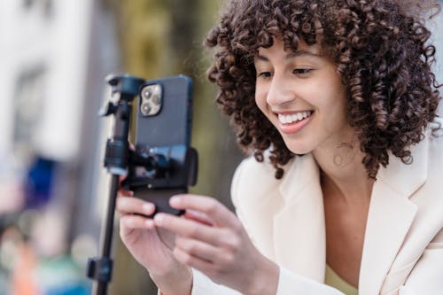 akıllı telefon, blazer ceket, bukleli saç içeren Ücretsiz stok fotoğraf